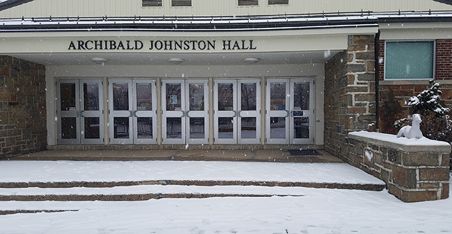 The snow is falling outside Johnston Hall.