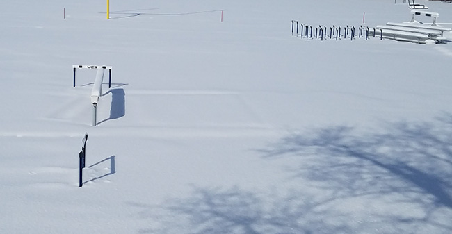 The steeplechase water jump under snow at Timothy Breidegam Track.