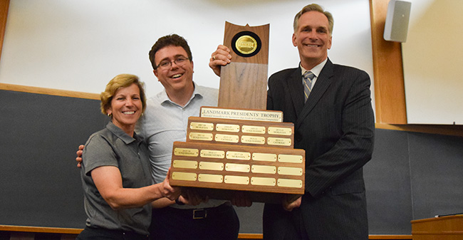 Mary Beth Spirk, Landmark Conference Commissioner Dan Fisher and President Bryon L. Grigsby '90 with the Landmark Conference Presidents' Trophy at the final faculty meeting of the 2017-18 academic year.