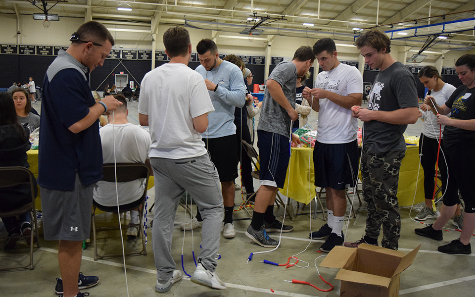 Members of Greyhounds' baseball and softball teams work on making jump ropes for the Boys & Girls Club as part of Moravian's Third Annual Heritage Day on September 26, 2018.