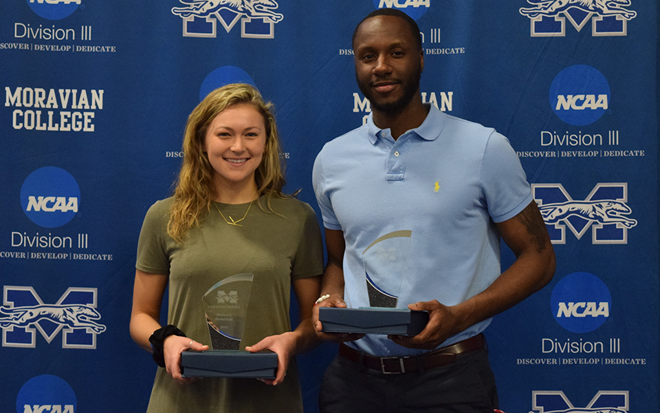 Juniors Karlie Brogan and John Hargraves accept the awards for the most community service hours for the men's and women's basketball teams.