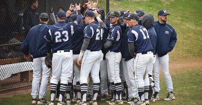 The Greyhounds huddle in front of the dugout in a game versus Drew University at Gillespie Field.
