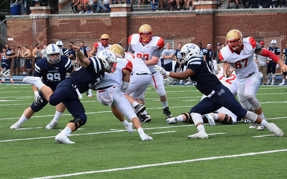 Sophomore Austin Heisler, freshman Tijir Bleam and junior Christian Coia combine on a sack versus King's College on September 1 on the Monarchs' final offensive play of the game to preserve a shutout by the Hounds.