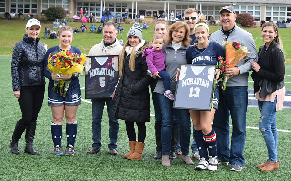 Seniors Emily Duddy and Elizabeth Hrehovcik with the families on Senior Day prior to the Greyhounds' match versus Goucher College on John Makuvek Field.