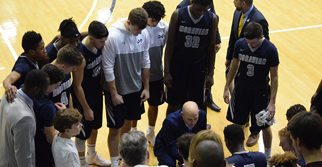 The Greyhounds huddle with Head Coach Justin Potts during the 2018 Landmark Conference Championship game at Juniata College.