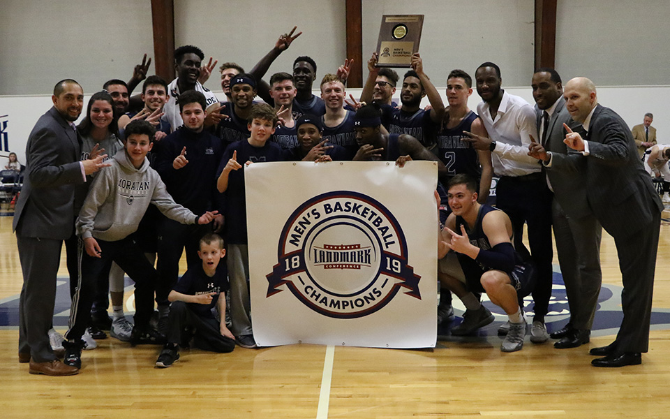 The Greyhounds with the 2019 Landmark Conference Championship banner and plaque after an 86-72 victory at Drew University.