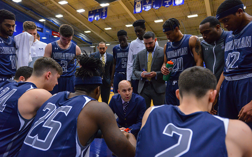 Head Coach Justin Potts talks to the Greyhounds during a timeout in the first half of Moravian's NCAA Division III Tournament First Round win over Keene State (N.H.) College in Clinton, N.Y. - Photo by Josh McKee.