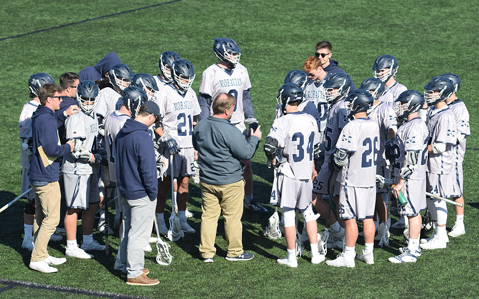 Head Coach Dave Carty talks with his offense during a timeout versus Rosemont College on John Makuvek Field.