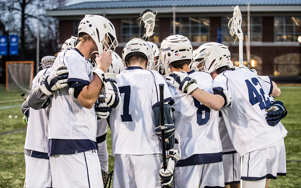 The Greyhounds huddle before a match with DeSales University on John Makuvek Field during the 2022 season. Photo by Cosmic Fox Media / Matthew Levine '11