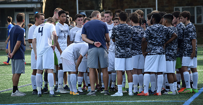 The Hounds huddle before the start of a match with Goucher College on John Makuvek Field.