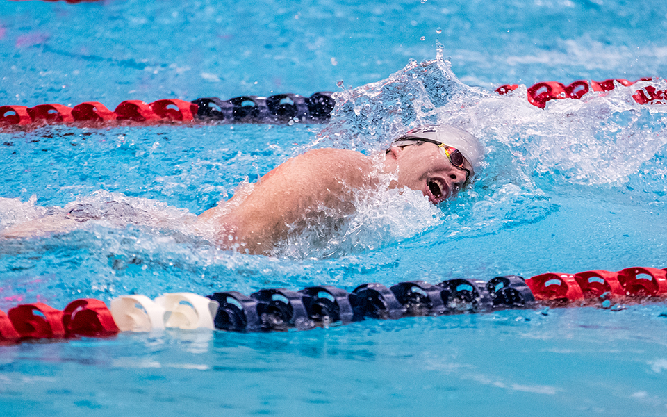 Junior Harrison Ziegler swims the freestyle in a double dual meet during the 2022-23 season at Liberty High School's Memorial Pool. Photo by Cosmic Fox Media / Matthew Levine '11