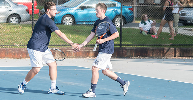 Isaac Schefer '19 and Peter Demyan '19 celebrate after winning a point in doubles action versus DeSales University in September 2017.