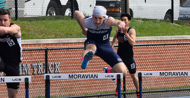 John Spirk '19 goes over a hurdle on his way to first place in the event at the Greyhound Invitational.