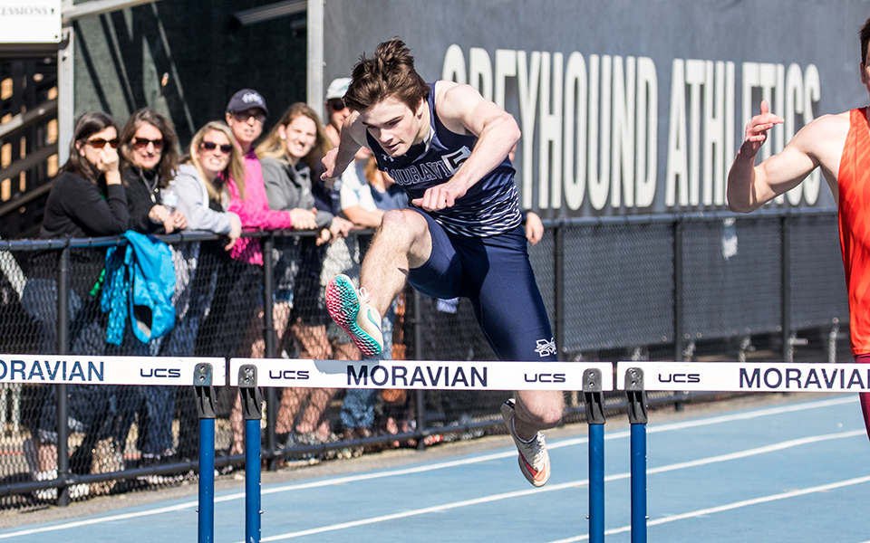 Freshman Jason Gartner clears a hurdle in the home stretch of the 400-meter hurdles in the Greyhound Invitational. Photo by Cosmic Fox Media / Matthew Levine '11
