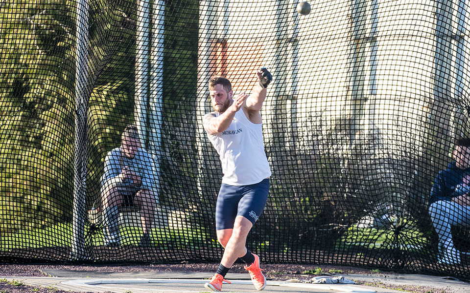 Graduate student Shane Mastro competes in the hammer throw during the Greyhound Invitational at Timothy Breidegam Track in April 2022. Photo by Cosmic Fox Media / Matthew Levine '11