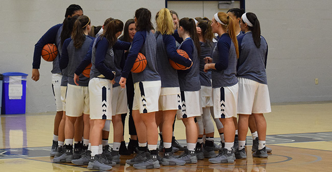 The Greyhound women huddle before before a game in Johnston Hall.