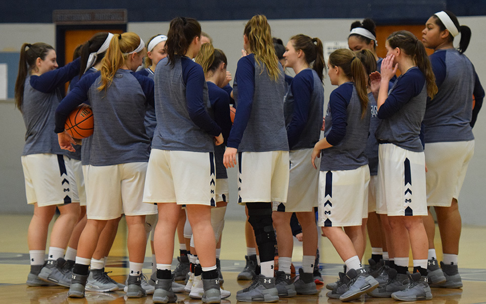 The Greyhounds huddle before a Landmark Conference game versus Goucher College in January 2018.