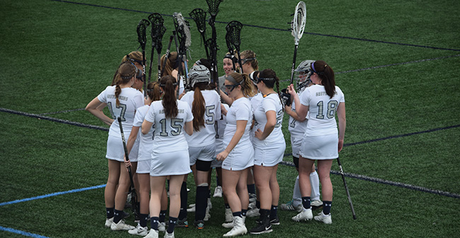 The Greyhounds huddle on John Makuvek Field before a match during the 2017 season.