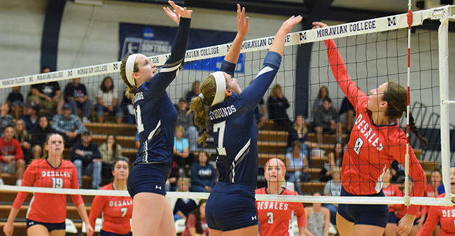 Erin Tiger '19 and Victoria Kauffman '20 go up for a block at the net against DeSales.