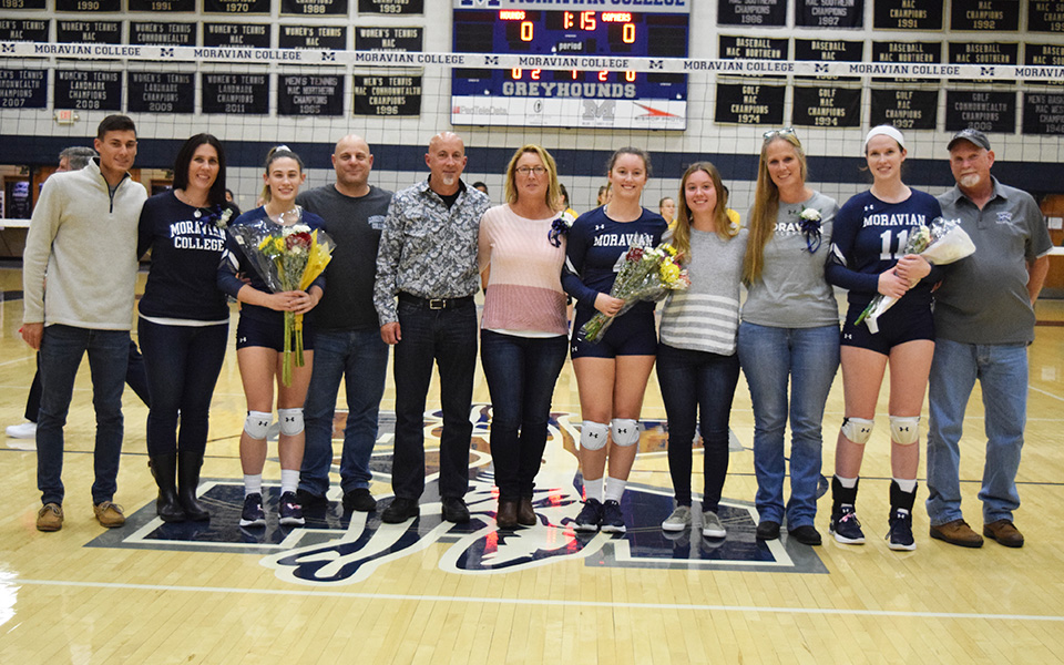 Seniors Brooke Kusmider, Rachel Farmer and Erin Tiger with their families on Senior Day in Johnston Hall versus Goucher College.