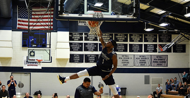 Khalil Rhett '18 throws down the winning dunk over assistant coach Ricky Hernandez in the Hoops Mania dunk contest.