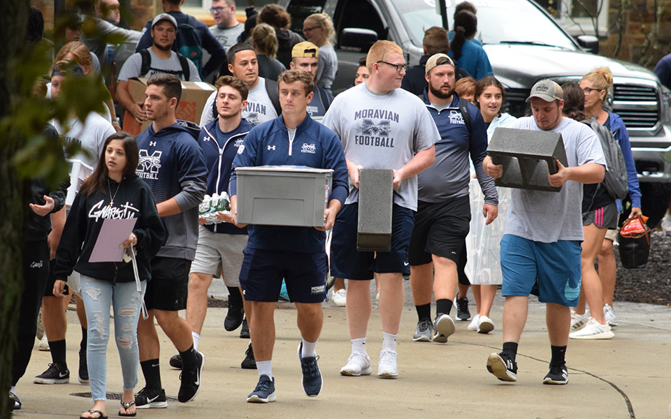 Members of the Moravian football team help unload vehicles during Freshman Move In day.