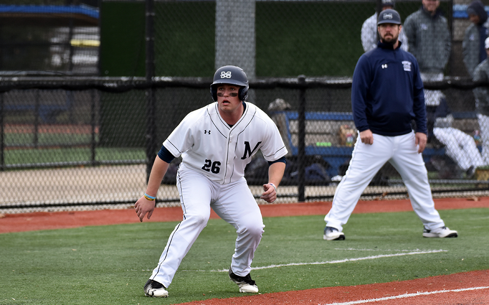 Senior Derek Holmes leads off third base with Head Coach Douglas Coe behind him in the 2023 season opening win over Elmira (N.Y.) College at Diamond Nation. Photo by Christine Fox