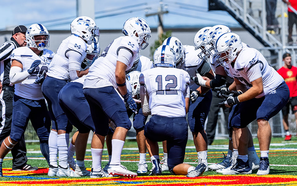 The Greyhounds offense huddles on the field during the 2021 season opener at King's College on September 4. Photo Courtesy of Tom Weishaar (OneMoreShot Photography)