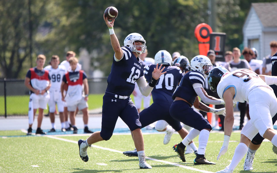 Quarterback Chris Mills throws a pass during a game versus No. 18 Johns Hopkins University at Rocco Calvo Field. Photo by Ashley Hacker '25.