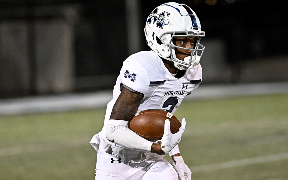 Graduate student Jalen Richardson returns a kickoff in a night game at nationally-ranked Johns Hopkins University earlier in the 2022 season. Photo courtesy of Johns Hopkins University Athletic Communications.