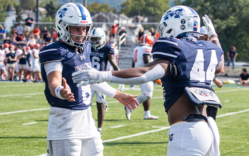 Senior quarterback Jared Jenkins and graduate student running back Joey Richmond celebrate a touchdown versus Utica (N.Y.) University at Rocco Calvo Field earlier this season. Photo by Cosmic Fox Media / Matthew Levine '11