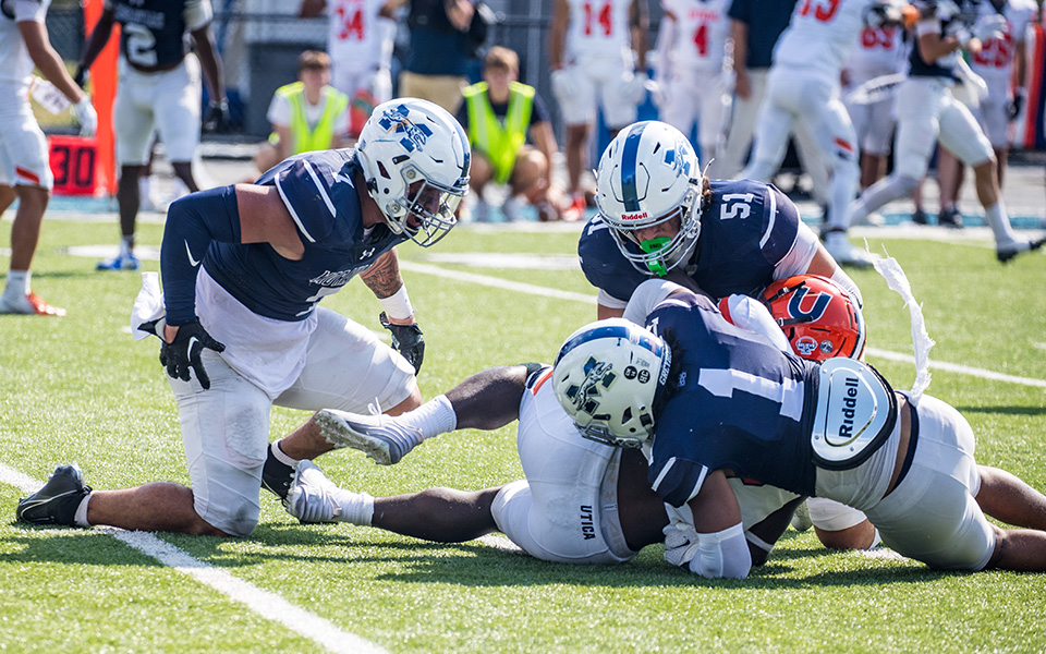 Senior linebacker Chris Cacace, senior defensive back Isaiah Johnson and junior linebacker Ethan O'Neil made a tackle versus Utica (N.Y.) University at Rocco Calvo Field earlier this season. Photo by Cosmic Fox Media / Matthew Levine '11