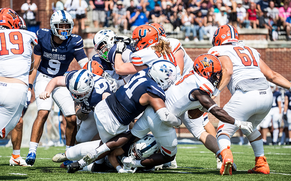 The Moravian defense makes a stop on a running play versus Utica (N.Y.) University at Rocco Calvo Field this season. Photo by Cosmic Fox Media / Matthew Levine '11