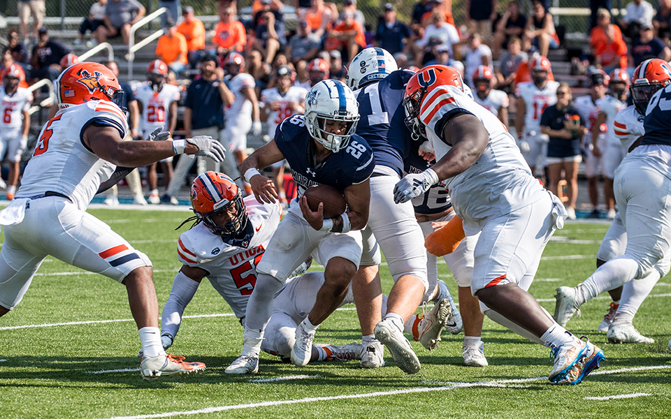 Junior running back Isiah Rico runs through a hole versus Utica (N.Y.) University at Rocco Calvo Field earlier this season. Photo by Cosmic Fox Media / Matthew Levine '11