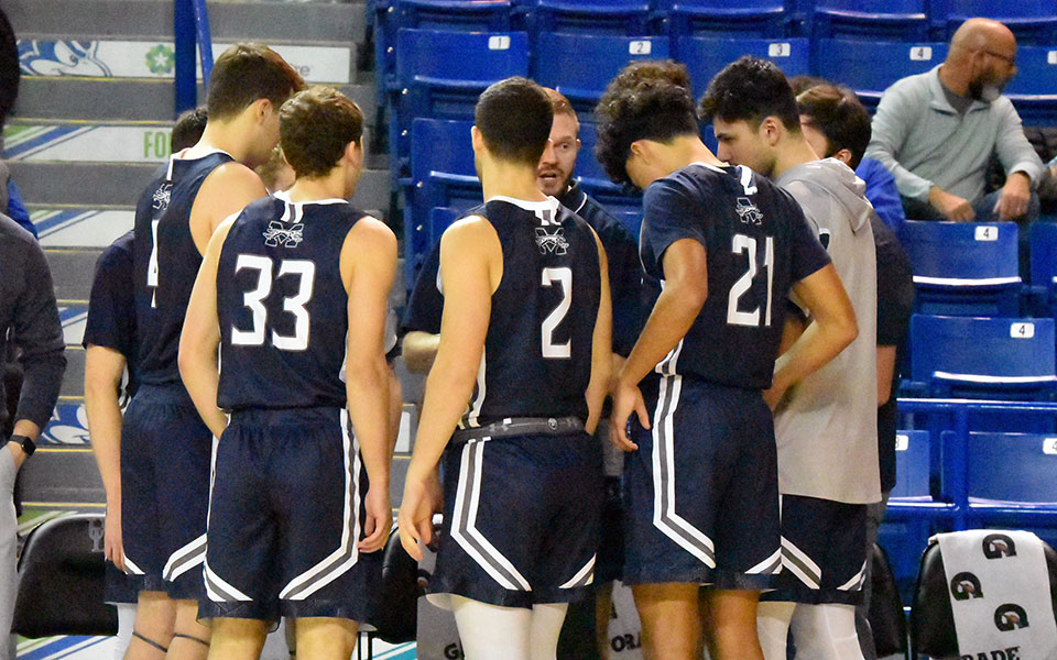 The Greyhounds huddle during their exhibition game at The University of Delaware in December.