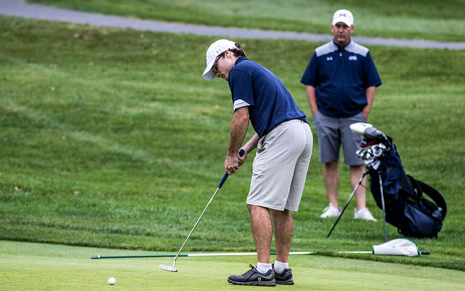 Junior Andrew Hozza putts during the John Makuvek Cup in October 2021 at the Lehigh Country Club with Head Coach Kevin Edwards '96 watching. Photo by Cosmic Fox Media / Matthew Levine '11