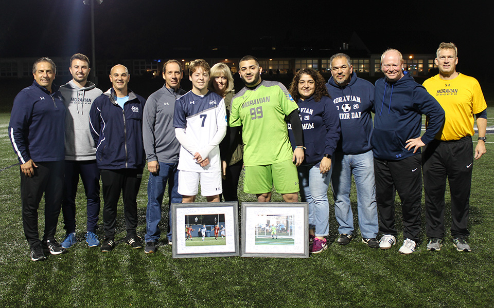 Seniors Jon Matthews and Yamil Yunez with their parents and the Greyhounds' coaching staff on Senior Night prior to defeating DeSales University on John Makuvek Field.