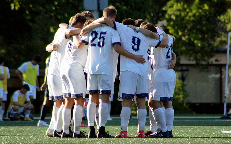 The Greyhounds huddle before a match on John Makuvek Field during the 2021 season. Photo by Marissa Werner '23