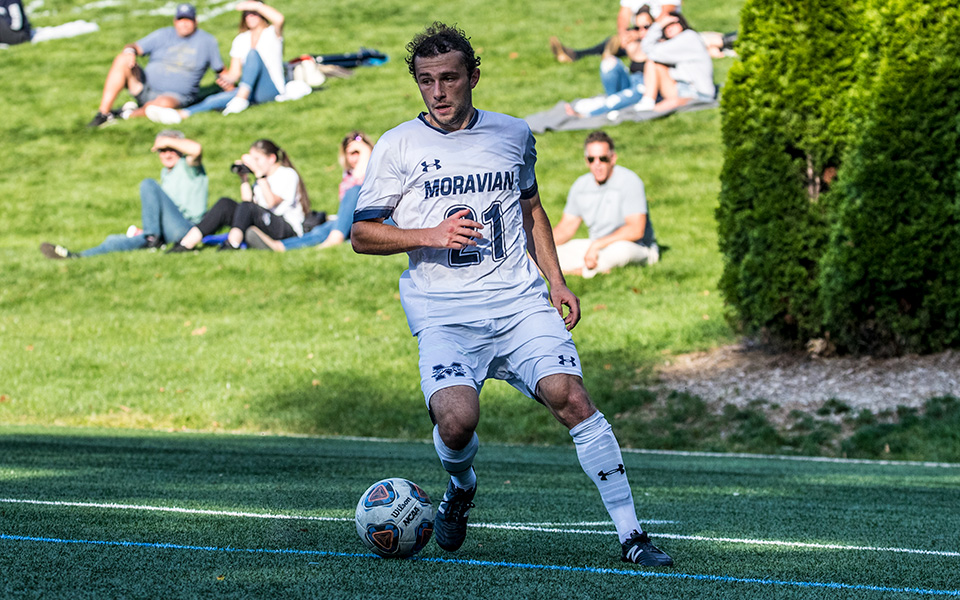 Alec Aloia gets set to cross the ball in a match versus Goucher College on John Makuvek Field during the 2021 season. Photo by Cosmic Fox Media / Matthew Levine '11