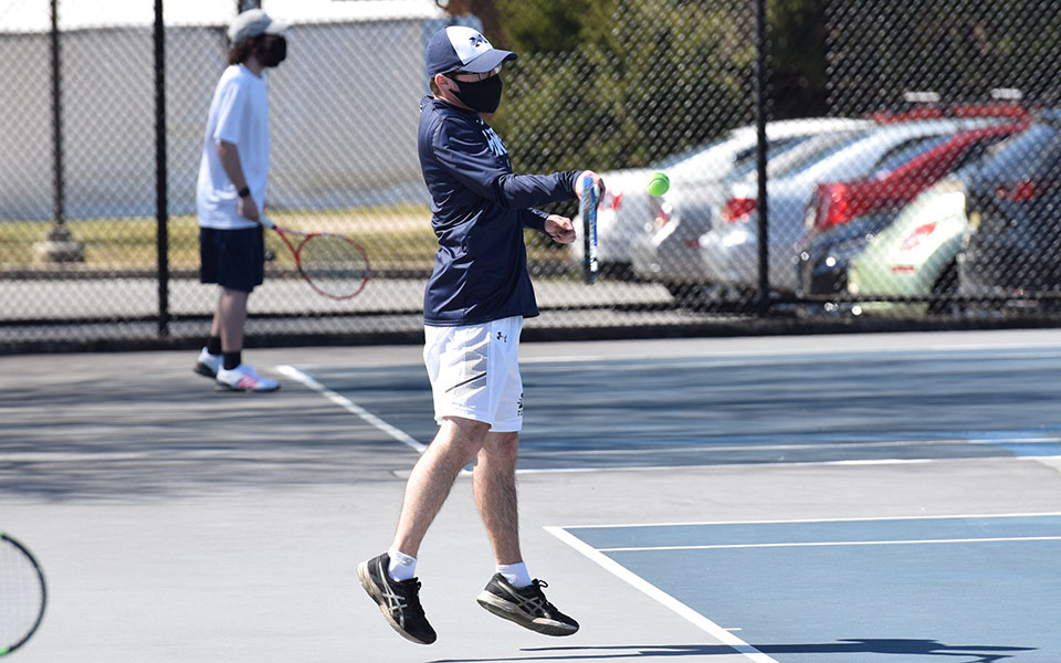 Andrew Hozza '23 returns a shot during doubles action versus Immaculata University at Hoffman Courts.
