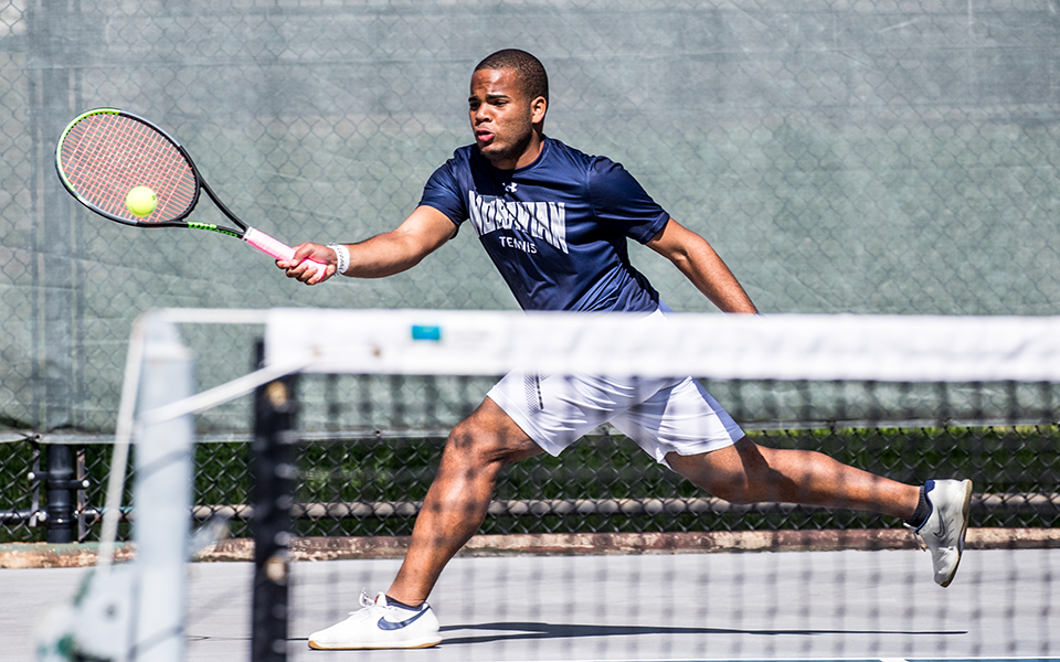Freshman Ronny Pimental Ferrer returns a shot versus Alvernia University during the fall portion of the 2021-22 season out of Hoffman Courts. Photo by Cosmic Fox Media / Matthew Levine '11