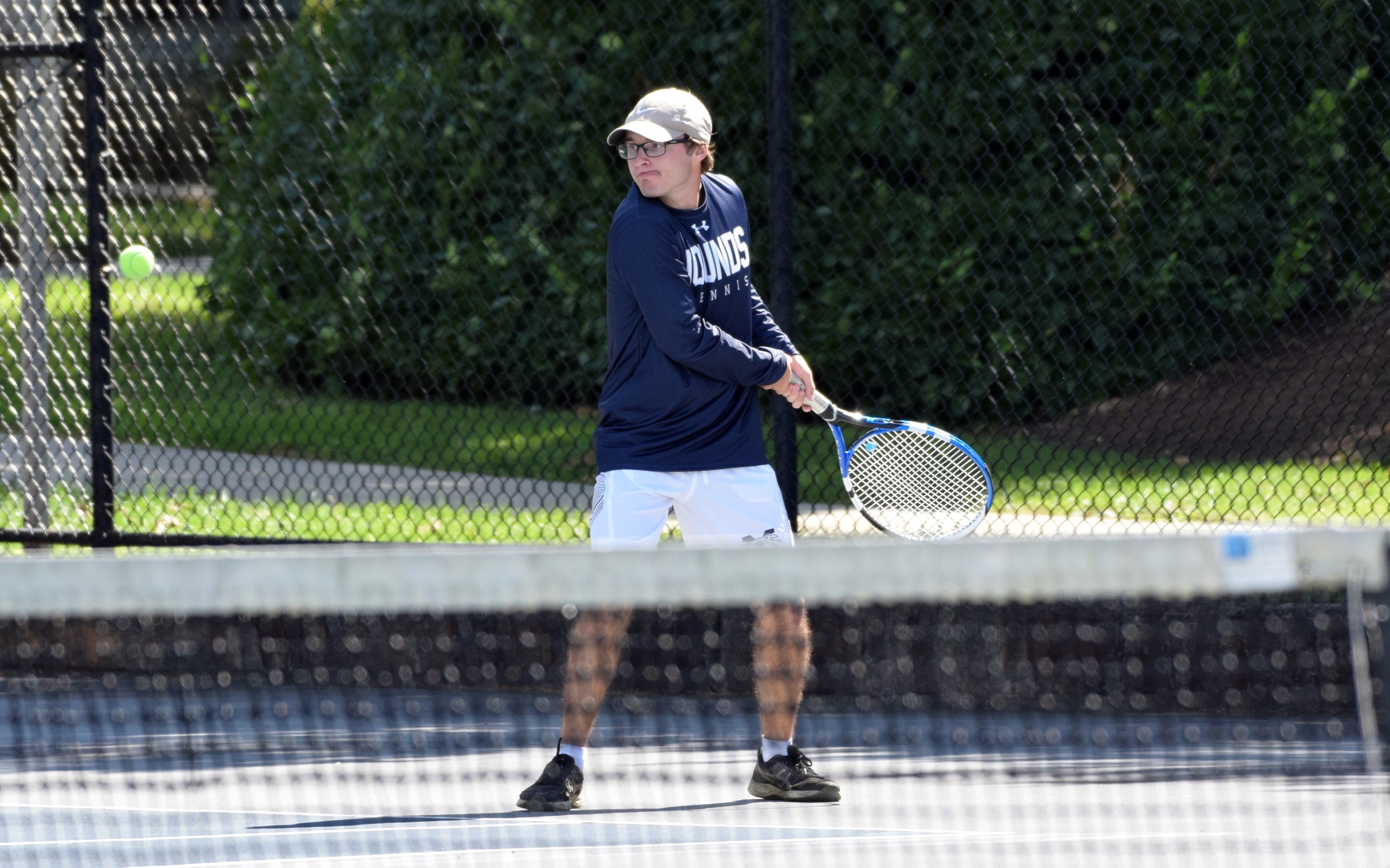 Junior Andrew Hozza returns a shot over the net at Hoffman Courts.