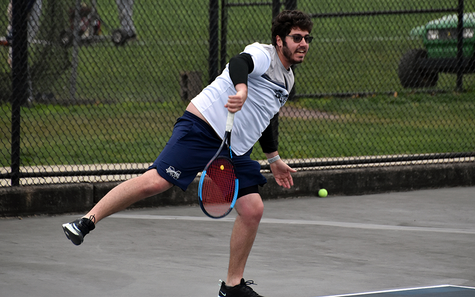 Senior Justin Szaro follows through on a serve in doubles action versus Penn State Brandywine at Hoffman Courts. Photo by Christine Fox