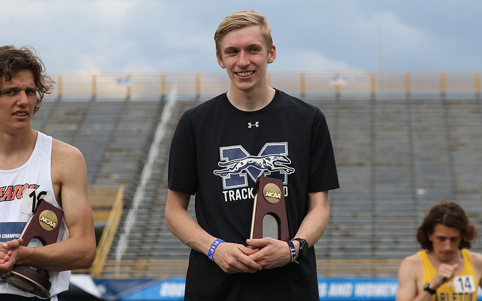 Graduate student Greg Jaindl '20 on the podium after his third place finish in the 3,000-meter steeplechase at the 2021 NCAA DIII National Championships to earn All-America honors. Photo courtesy of d3photography.com