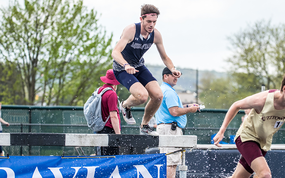 Graduate student Christian Jancsarics goes over the water hurdle during the 3,000-meter steeplechase at the Coach Pollard Invitational in April 2023. Photo by Cosmic Fox Media / Matthew Levine '11