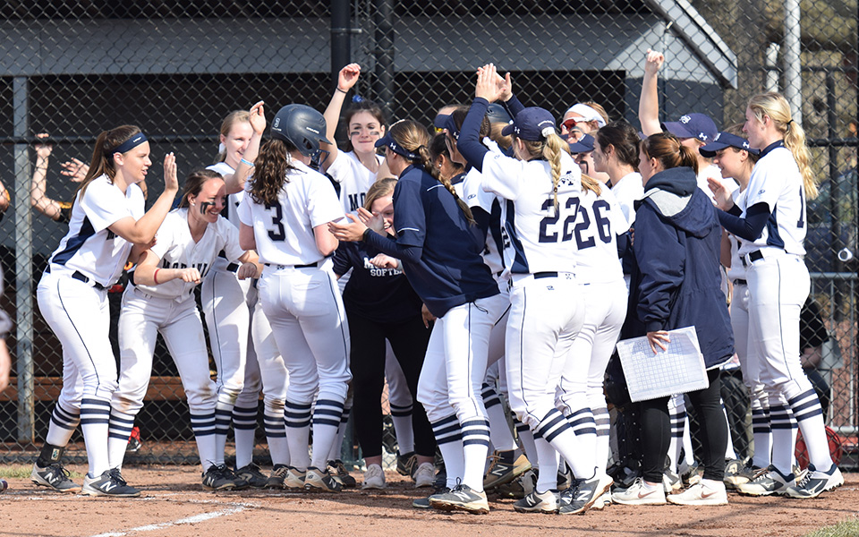 The Greyhounds greet junior Lauren Goetz at home after one of her two home runs in the 2019 home opener versus Gwynedd Mercy University at Blue & Grey Field.