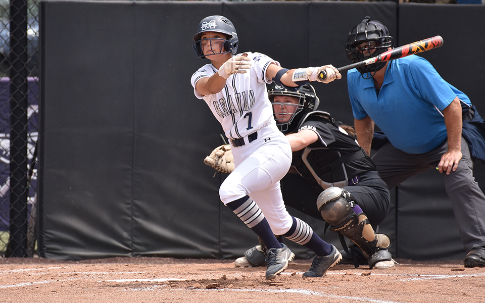 Sophomore third baseman Holly Walter watches her three-run homer in the first inning of the Landmark Conference Tournament win versus The University of Scranton at Blue & Grey Field sail towards the outfield. Photo by Christine Fox