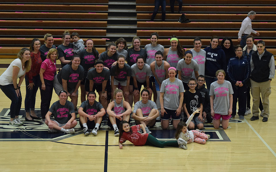 The women's basketball alumni gather at center court after their annual Alumni game in Johnston Hall.