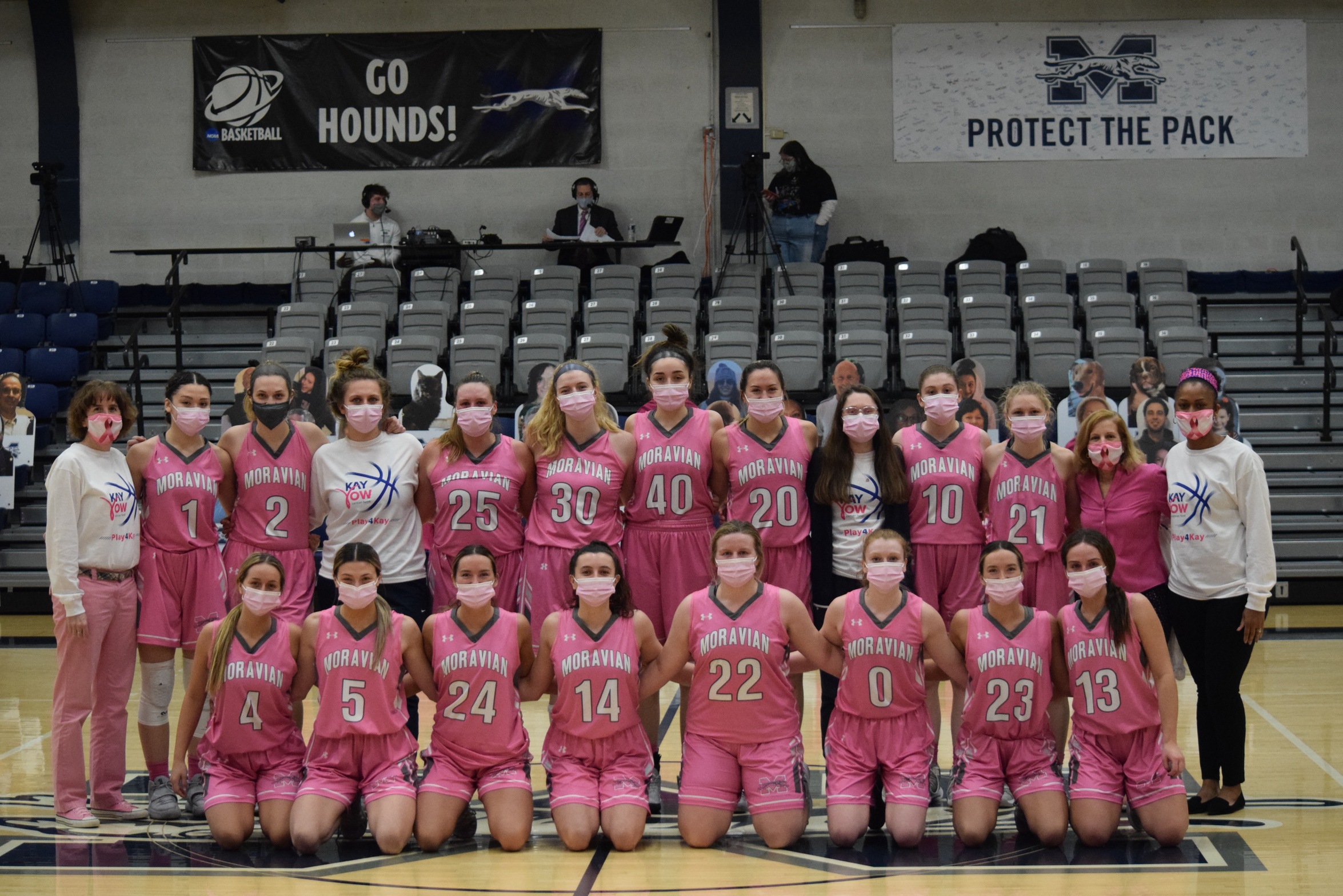 The Greyhounds together at center court in their pink jerseys after defeating Yeshiva in the program's annual Play4Kay game.