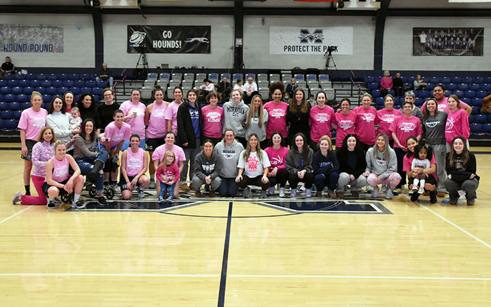 All the attendees of the 2022 women's basketball alumni game and the current members of the 2021-22 basketball squad at center court in Johnston Hall.